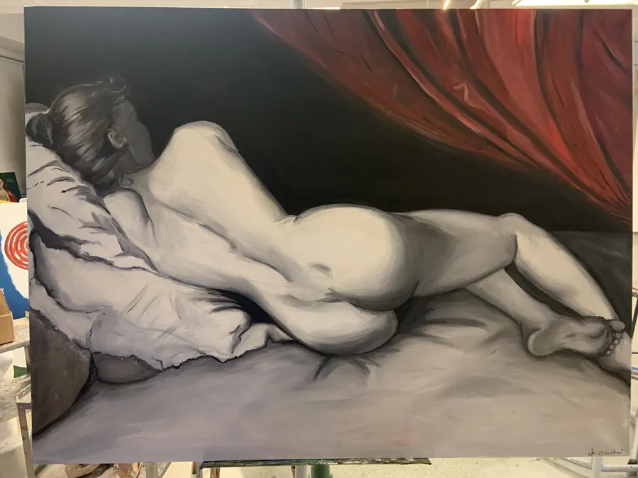Reclining nude in greyscale beneath a red curtain